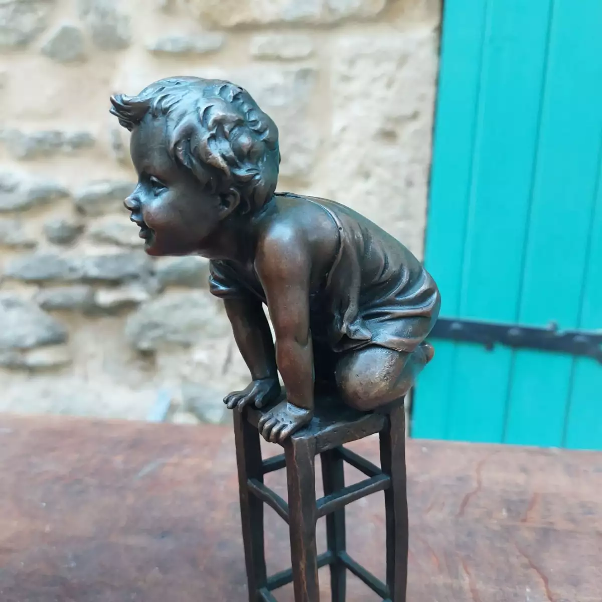 Sculpture en bronze de M Juan CLARA, enfant sur tabouret