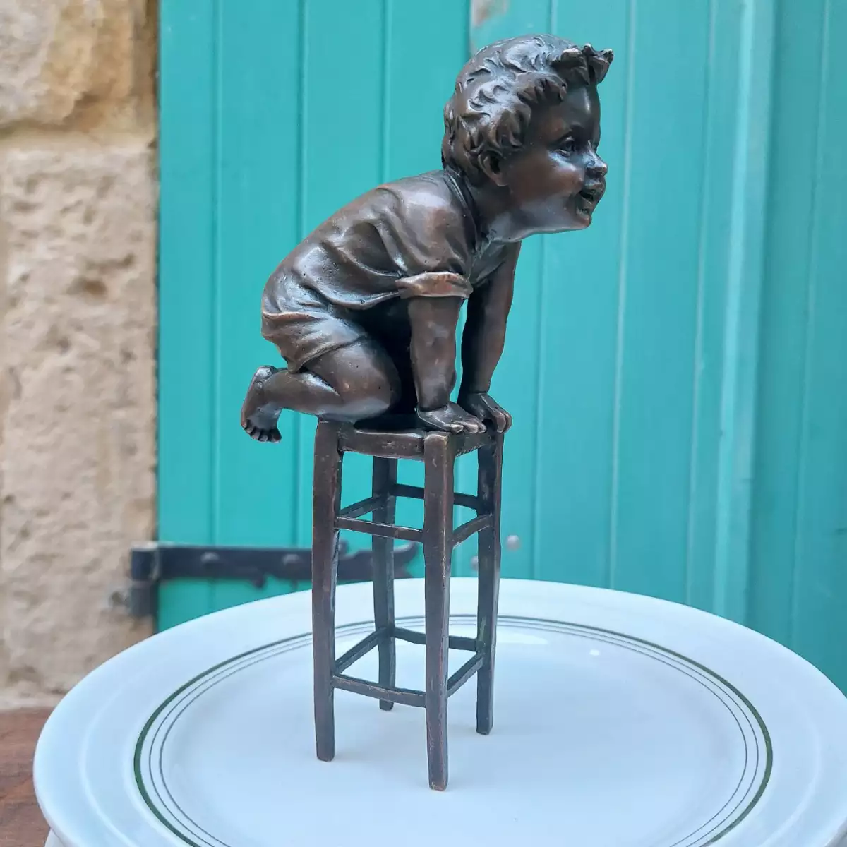 Sculpture en bronze de M Juan CLARA, enfant sur tabouret